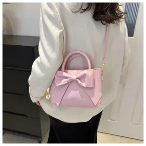 Detail of pink bow handbag with detachable shoulder strap and matte PU leather texture
