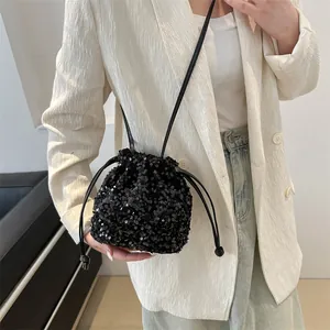 Fashionable black sequin bucket bag with drawstring closure and slim shoulder strap