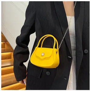Chic yellow jelly crossbody bag with pearl detail shown on model in black blazer