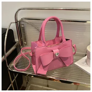 Nahaufnahme der pinkfarbenen Handtasche mit großer Schleife und Herz-Strass-Anhänger