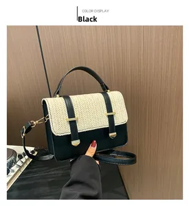 Détail du sac bandoulière en paille bicolore avec cuir noir et finitions dorées