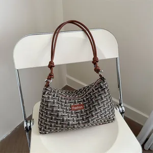 Elegante borsa in tweed con manico a catena ed etichetta Fashion su sedia bianca