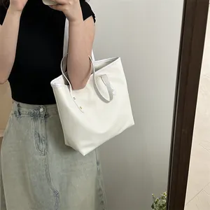Minimalist creamy white leather tote bag with large capacity and gold rivet accents
