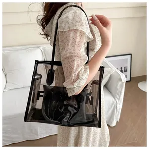Detail of transparent PVC tote bag with FASHION lettering and internal pouch