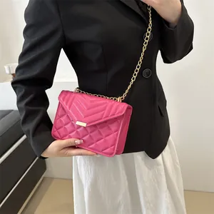 Quilted rose pink crossbody bag with V-shaped stitching and gold chain strap