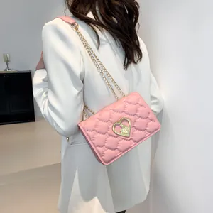 Sac à bandoulière en cuir matelassé rose avec emblème de cœur doré et bandoulière chaîne