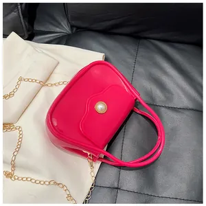 Detailed macro view of the hot pink jelly bag with a large gold-rimmed pearl closure