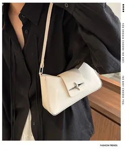 Gros plan du sac baguette crème en similicuir avec boucle étoile argentée élégante
