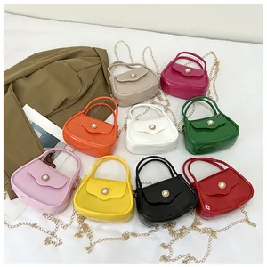 Flat lay of colorful mini jelly bags with pearl buckles and gold chain straps