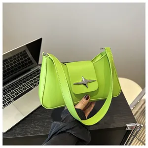 Détail du sac baguette vert fluo avec boucle en forme d'étoile argentée en cuir