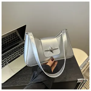 Détail du sac baguette argenté avec boucle étoile métallique et finition en similicuir