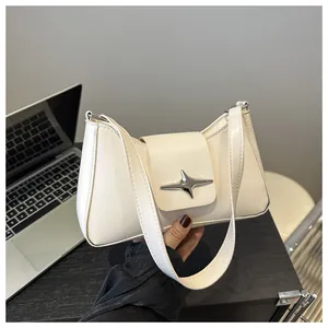 Détail du sac baguette crème avec boucle étoile argentée et texture en cuir lisse