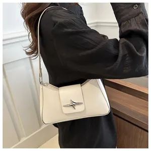 Détail du sac baguette croissant blanc crème avec boucle étoile argentée à l'épaule