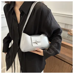 Détail du sac baguette argenté avec boucle étoile et fine bandoulière élégante