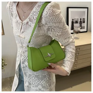 Détail du sac sous l'aisselle vert herbe avec une boucle métallique en forme d'étoile