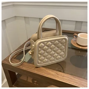 Detail of quilted rhombic pattern on cream PU leather crossbody handbag for women