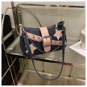 Detail of Y2K denim shoulder bag featuring pink star patches and metal chain strap