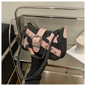 Close-up of trendy denim underarm bag featuring pink stars and silver buckle