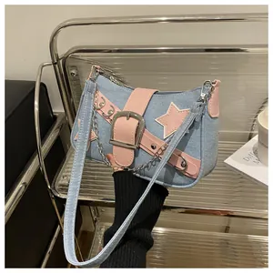 Detail of Y2K denim shoulder bag with pink stars and metallic buckle on its chain