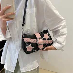 Denim crescent shoulder bag with pink star patches and metallic chain details