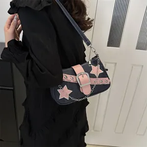 Y2K denim shoulder bag with pink star patches and metallic chain detail on model