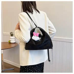 Detail of black velvet hobo bag featuring silver chain and cute plush rabbit charm