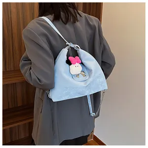Side view of light blue hobo bag with silver bow detail and fluffy plush charm