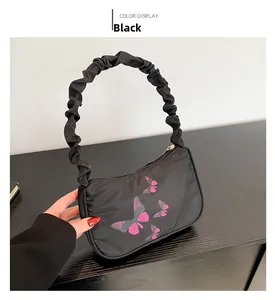 Close-up of black nylon shoulder bag with pink butterfly print and ruched cloud handle