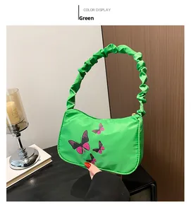 Detail of green shoulder bag with butterfly print and stylish scrunchie handle strap