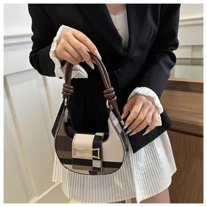 Detail der sichelförmigen Schultertasche mit Patchwork-Karomuster und goldener Schnalle