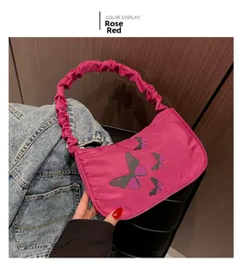 Detail of rose red baguette bag featuring butterfly print and scrunchie pleated handle