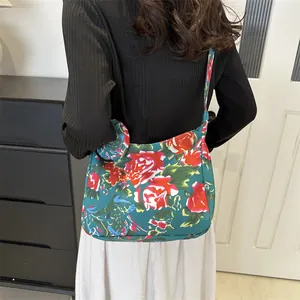 Retro floral canvas tote bag with large rose patterns worn by a model in a minimal setting