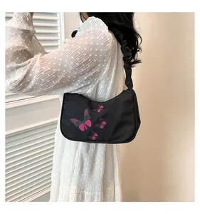Detail of black underarm bag with pink butterfly print and stylish ruched shoulder strap