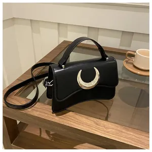 Détail du sac carré noir à texture litchi avec boucle argentée en forme de croissant