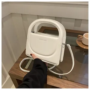 Detail of white leather handbag with semi-circular handle and Fashion & Bags text