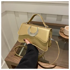 Détail du sac à main doré champagne avec une grande boucle argentée en forme de croissant