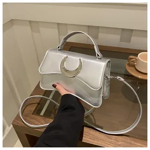 Détail du sac à bandoulière argenté avec boucle en croissant de lune et poignée chic