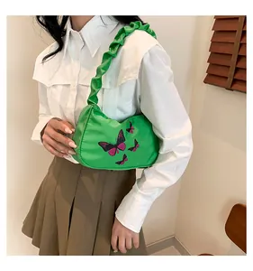 Close-up of bright green fabric shoulder bag with butterfly print and ruched handle
