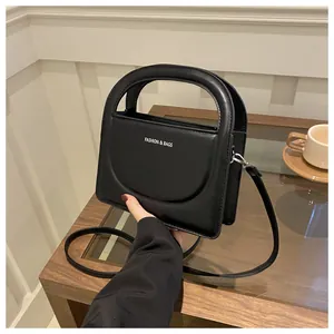 Detail of black leather small square bag with Fashion & Bags print and top handle