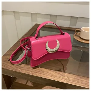 Détail du sac fuchsia à motif litchi avec une boucle en croissant de lune argentée