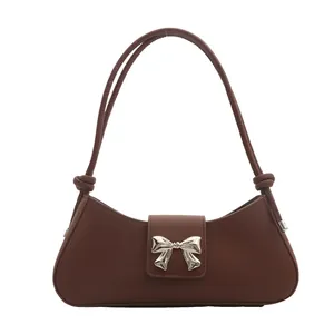 Brown French-style underarm bag with a silver metal bow buckle and elegant shoulder knots
