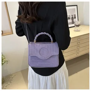 Detail of lavender purple crocodile pattern faux leather handbag with braided handle