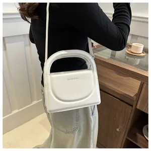 Detail of matte white PU leather crossbody bag with FASHION & BAGS logo text