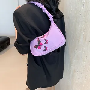 Y2K purple butterfly shoulder bag with pleated scrunchie strap on model's shoulder