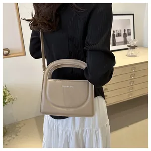 Detail of a khaki PU leather crossbody bag with Fashion & Bags text on model