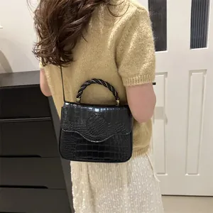 Fashionable black crocodile textured handbag with chain handle and adjustable strap