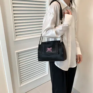Sac à épaule en velours noir chic avec broderie papillon rose et bandoulière en chaîne dorée