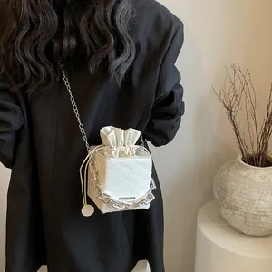 Minimalist white box crossbody bag with drawstring closure and chain strap for women