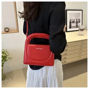 Detail view of red PU leather handbag with white Fashion & Bags text logo and strap