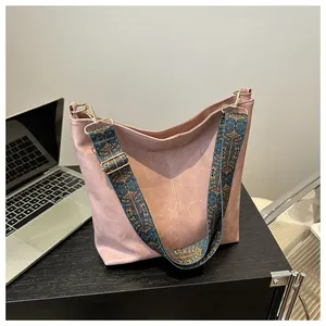 Detail of hobo bag with vintage leather texture and colorful ethnic style strap